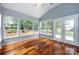 Inviting sunroom features hardwood floors, neutral paint, ceiling fan and access to patio at 1040 Stonedown Ln, Matthews, NC 28104