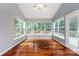 Bright sunroom with hardwood floors, neutral paint and many windows overlooking backyard at 1040 Stonedown Ln, Matthews, NC 28104