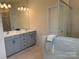 Bathroom featuring double sinks with modern fixtures and vanity with shaker style cabinets at 10417 Bluejack Oak Ct, Huntersville, NC 28078