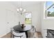 Cozy dining area featuring a modern light fixture, round table with four chairs, and a large window offering natural light at 1101 Plaza Walk Dr, Charlotte, NC 28215