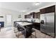 Modern kitchen with stainless steel appliances, dark wood cabinets, a center island with seating, and hardwood floors at 1101 Plaza Walk Dr, Charlotte, NC 28215