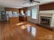 Open-concept living space connects kitchen with a brick fireplace, and hardwood floors at 1116 Fieldstone Rd, Mooresville, NC 28115
