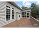 Back deck featuring wood flooring and steps down to the grassy yard with sunroom in background at 1119 Williamstown Rd, Matthews, NC 28105