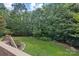 Lush backyard with mature trees, green grass, and view of the house from the deck at 1119 Williamstown Rd, Matthews, NC 28105
