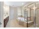Spacious bathroom featuring soaking tub, glass-enclosed shower, double sink vanity and tile floors at 1119 Williamstown Rd, Matthews, NC 28105