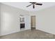 Bedroom with neutral paint, carpet, and ceiling fan, with view into attached bathroom at 1119 Williamstown Rd, Matthews, NC 28105