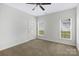 A bright bedroom has neutral paint, ceiling fan, carpet and great natural light from windows at 1119 Williamstown Rd, Matthews, NC 28105