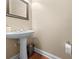 Well-lit half-bath features a pedestal sink and hardwood floors at 1119 Williamstown Rd, Matthews, NC 28105