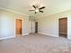 Large main bedroom with ceiling fan, neutral walls, carpet, and ensuite bathroom and walk-in closet at 11533 Valley Oak Ln, Stanfield, NC 28163