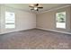 Spacious bedroom with plush carpet, bright windows, ceiling fan, and paneled accent wall at 11533 Valley Oak Ln, Stanfield, NC 28163