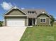 Charming home with a white garage door and beautifully landscaped front yard at 11533 Valley Oak Ln, Stanfield, NC 28163