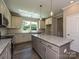 Bright kitchen features stainless appliances, granite counters, an island, and wood floors at 11533 Valley Oak Ln, Stanfield, NC 28163