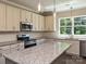 Modern kitchen featuring stainless steel appliances, granite countertops, and custom cabinetry at 11533 Valley Oak Ln, Stanfield, NC 28163
