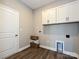 Functional laundry room with white cabinets, utility hookups, and vinyl flooring at 11533 Valley Oak Ln, Stanfield, NC 28163