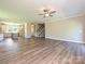 Open-concept living room, with stairs, and kitchen featuring wood floors and neutral walls at 11533 Valley Oak Ln, Stanfield, NC 28163