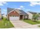 A well-manicured lawn and driveway leads to a brick home with a two-car garage at 11608 Downy Birch Rd, Charlotte, NC 28227