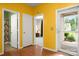 Hallway with yellow walls and hardwood floors leading to rooms and the front door at 11608 Downy Birch Rd, Charlotte, NC 28227