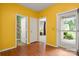 Hallway with yellow walls, hardwood floors, and a view to a bathroom and carpeted room at 11608 Downy Birch Rd, Charlotte, NC 28227