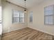 Bright bedroom with hardwood floors, large windows, and modern light fixture at 12131 Honor Guard Ave, Charlotte, NC 28277