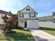Charming two-story home with a well-maintained lawn, driveway, and attached garage, situated under a bright, clear sky at 12131 Honor Guard Ave, Charlotte, NC 28277
