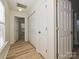 Bright hallway with hardwood floors and multiple doors, showcasing home's layout and storage at 12131 Honor Guard Ave, Charlotte, NC 28277