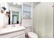 Bright bathroom with a white vanity, framed mirror, and shower with patterned curtain at 126 W Morehouse Ave, Mooresville, NC 28117