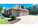 Spacious three-car garage with an adjacent entry door, and a well-maintained driveway surrounded by landscaped shrubs at 141 Castle Dr, Mooresville, NC 28117
