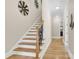 Hallway with hardwood floors, stylish lighting fixtures, and an inviting staircase to the upper level at 141 Castle Dr, Mooresville, NC 28117