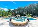 Backyard pool and jacuzzi with lounge seating, umbrellas, mature landscaping, and a pool house at 141 Castle Dr, Mooresville, NC 28117