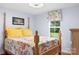 Bright bedroom with a wooden four post bed, floral quilt, and plenty of natural light at 1489 L R Schronce Ln, Iron Station, NC 28080