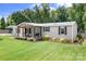 Charming manufactured home with a covered front porch and nicely landscaped yard at 1489 L R Schronce Ln, Iron Station, NC 28080