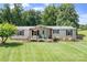 Charming single-story home features a covered porch, beautiful lawn, and mature trees in a serene setting at 1489 L R Schronce Ln, Iron Station, NC 28080