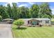 Ranch home with a covered front porch, manicured lawn, and detached carport at 1489 L R Schronce Ln, Iron Station, NC 28080