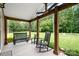 Cozy covered porch featuring a rocking chair, bench seating, and decorative plants, offering a relaxing outdoor space at 1489 L R Schronce Ln, Iron Station, NC 28080