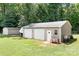 Two-car detached garage, a shed, and a camper parked in a grassy backyard at 1489 L R Schronce Ln, Iron Station, NC 28080