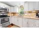 Bright kitchen featuring white cabinets, modern appliances, and stylish backsplash, designed for culinary enthusiasts at 1489 L R Schronce Ln, Iron Station, NC 28080