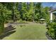 Beautiful backyard with a stone retaining wall, lush landscaping, and a patio set for outdoor dining at 17537 Caddy Ct, Charlotte, NC 28278