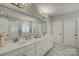 Bright bathroom with double vanity, quartz countertops, and a large framed mirror at 17537 Caddy Ct, Charlotte, NC 28278