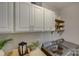 Well-organized laundry room featuring overhead cabinets, shelving, and modern washer/dryer units at 17537 Caddy Ct, Charlotte, NC 28278