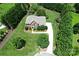 Aerial view of a brick home with manicured lawn, mature trees, and a long private driveway at 2019 Heirloom Ct, Matthews, NC 28104