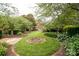 Well-maintained backyard featuring landscaped flower beds, a fire pit, and a green lawn for outdoor enjoyment at 2019 Heirloom Ct, Matthews, NC 28104