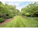 Lush backyard features manicured lawn, mulched flower beds and mature trees providing a private backyard sanctuary at 2019 Heirloom Ct, Matthews, NC 28104