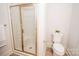 Bathroom featuring a glass enclosed shower and toilet with tiled floors at 2019 Heirloom Ct, Matthews, NC 28104