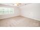 Bright bedroom with large window offers plenty of natural light and neutral carpet at 2019 Heirloom Ct, Matthews, NC 28104