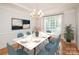 Bright dining room with a marble table, blue chairs, elegant chandelier, and modern decor at 2019 Heirloom Ct, Matthews, NC 28104