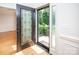 Elegant front door with decorative glass panes, wood floors and views of the front lawn and greenery outside at 2019 Heirloom Ct, Matthews, NC 28104