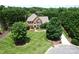Traditional brick home featuring a manicured lawn, mature trees, and a well-maintained landscape at 2019 Heirloom Ct, Matthews, NC 28104