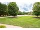 Well-maintained front yard featuring lush lawn, mature trees, and attractive landscaping at 2019 Heirloom Ct, Matthews, NC 28104