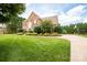 Beautiful brick home showcasing lush front lawn, landscaped shrubbery, and a curved driveway leading to a basketball court at 2019 Heirloom Ct, Matthews, NC 28104