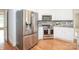 Modern kitchen with stainless steel appliances, white cabinets, and tile backsplash at 2019 Heirloom Ct, Matthews, NC 28104
